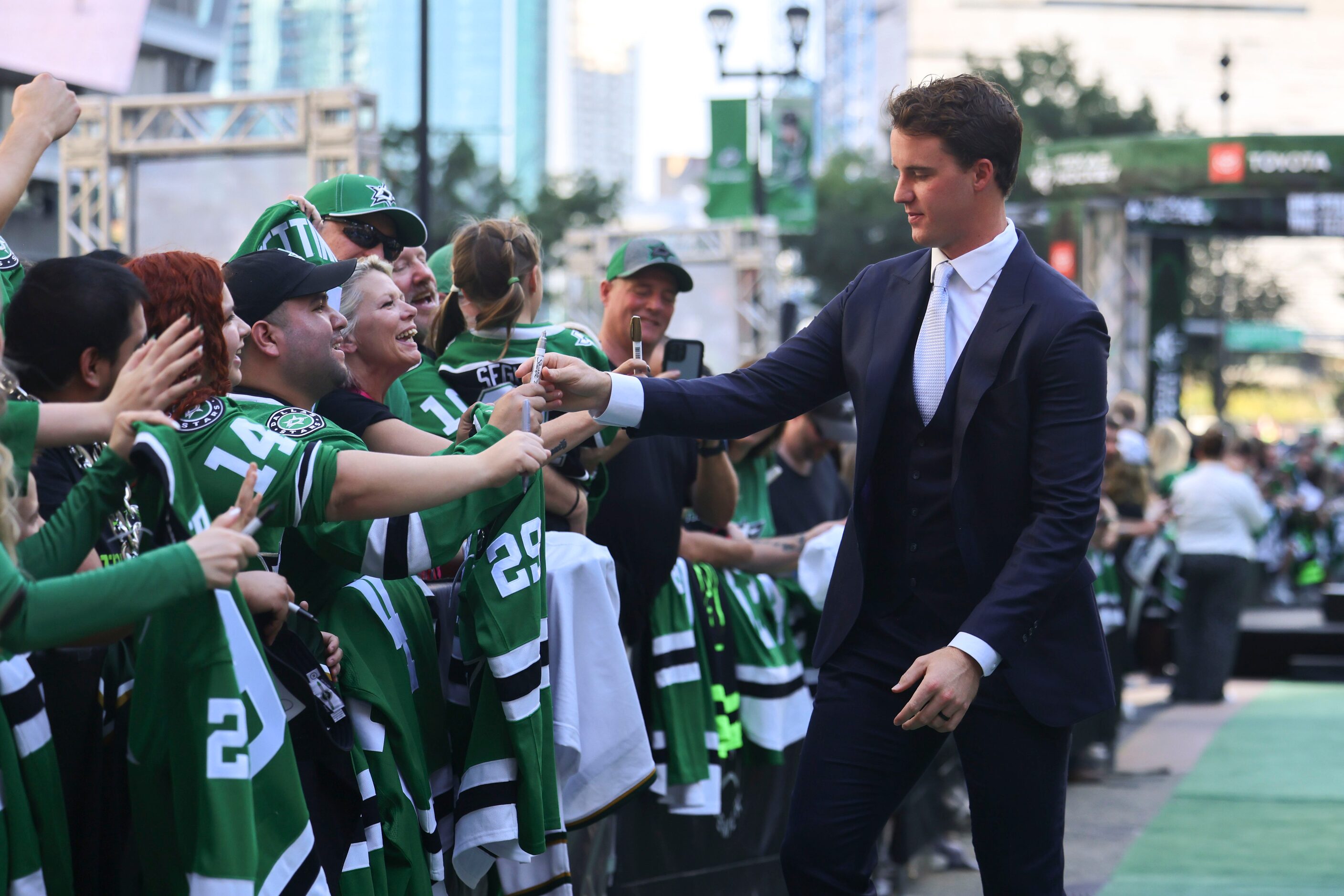 Dallas Stars goaltender Jake Oettinger gives autographs to fans as he makes his way during...