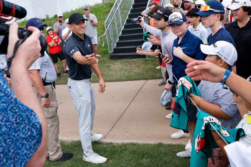 Jordan Spieth tosses a marker back to a fan after signing autographs after finishing the...