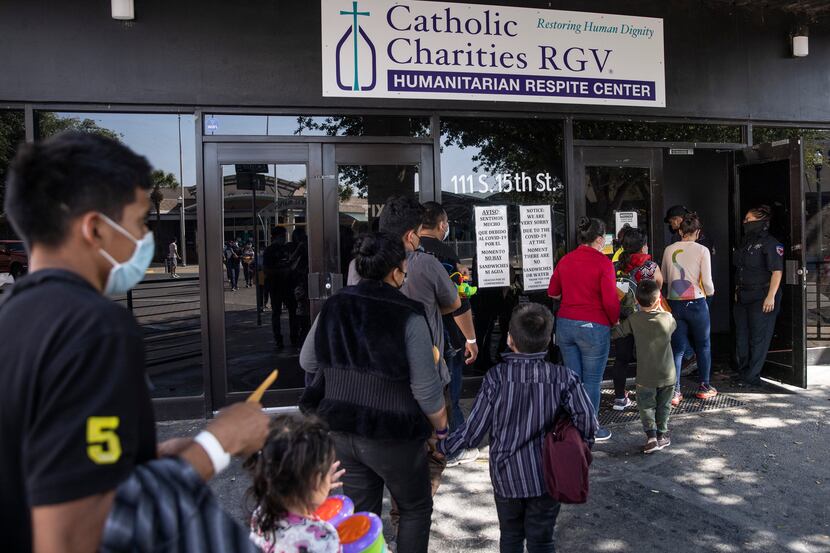 Families with very young children, likely under the age of 6, arrive to the Catholic...