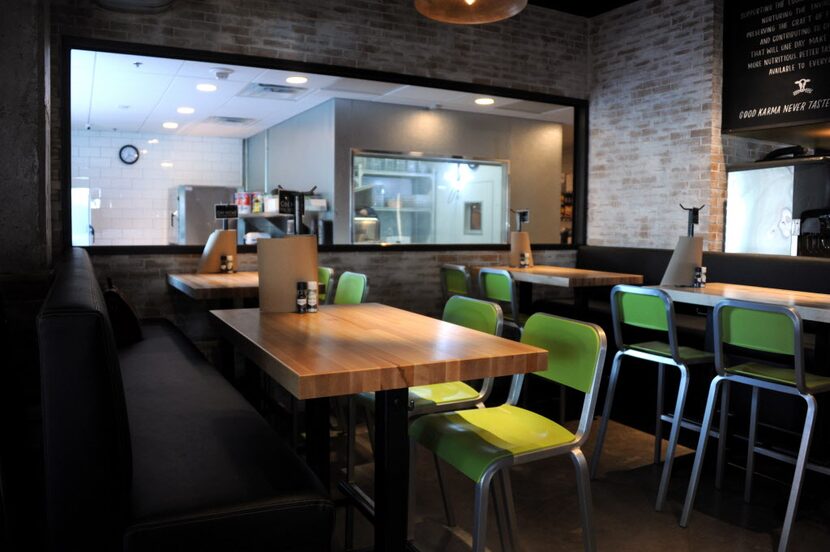 Guests can sit to eat their burger next to the bakery window and watch the burger buns being...