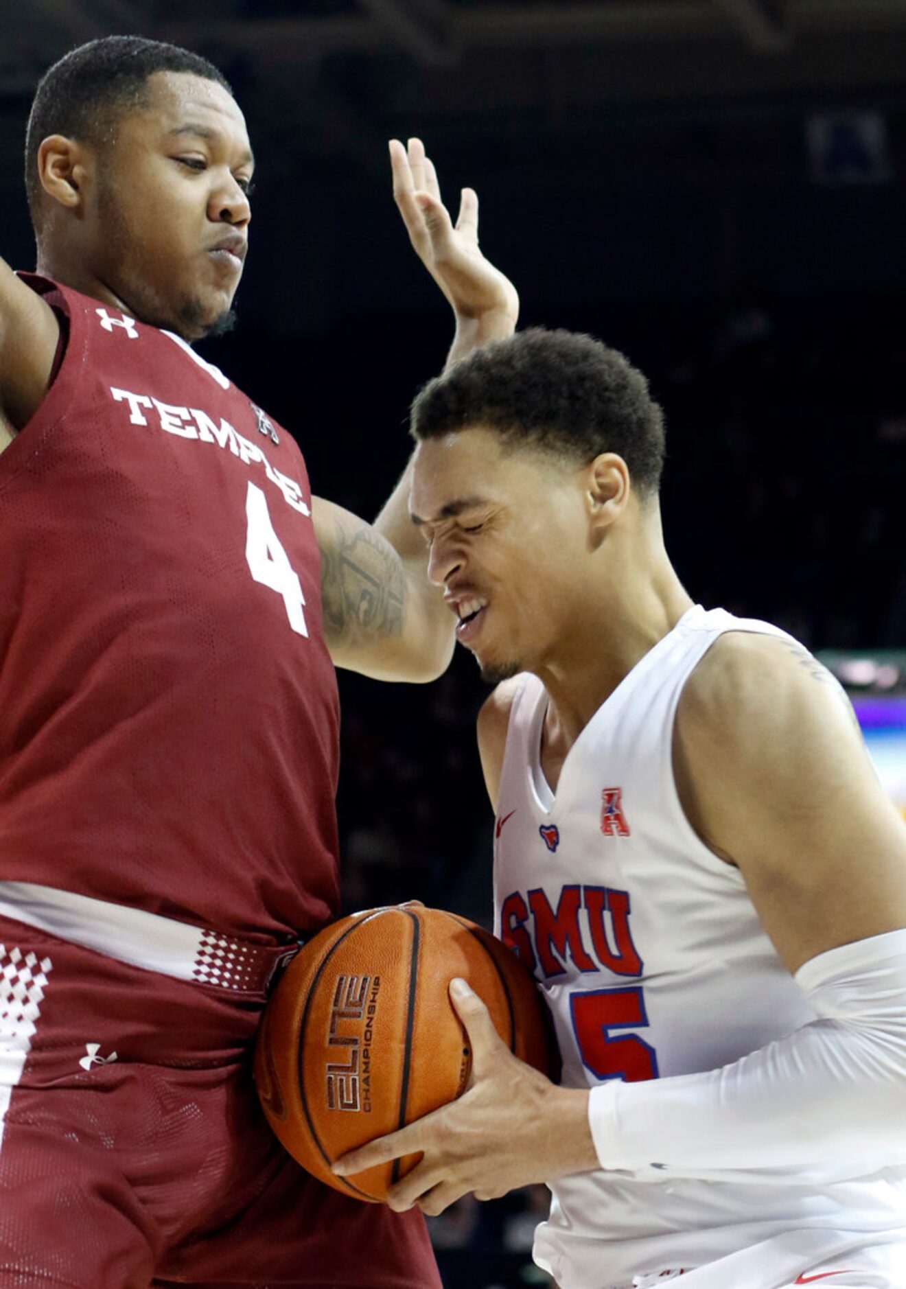 SMU forward Ethan Chargois (25) winces as he met inside resistance by Temple forward J.P....