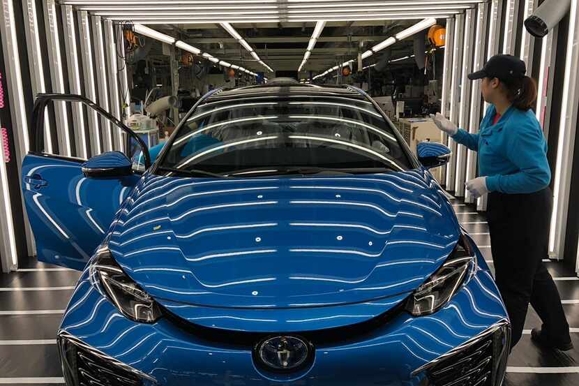 Workers putting the finishing touches on a car at Toyota's factory in its Japanese hometown,...
