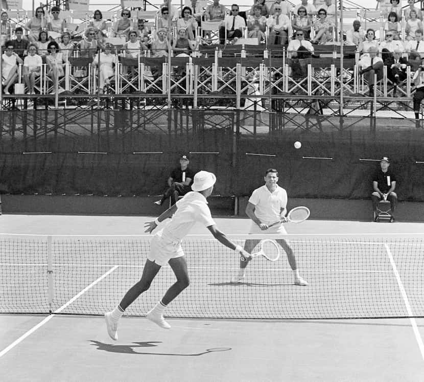 Arthur Ashe, foreground, of the U.S., and Mexico's Antonio Palafox work in close to the net...
