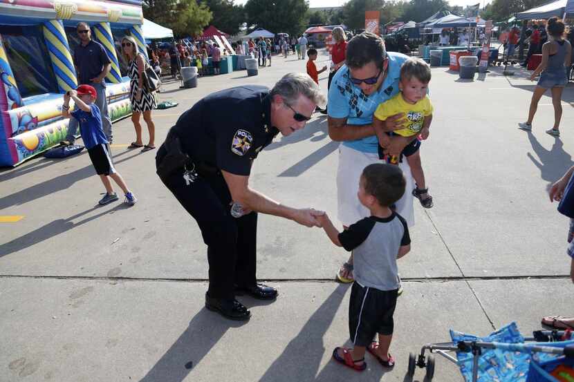 Rockwall Police Chief Kirk Riggs greets Aaron González and his sons, Tanner González, 1, and...