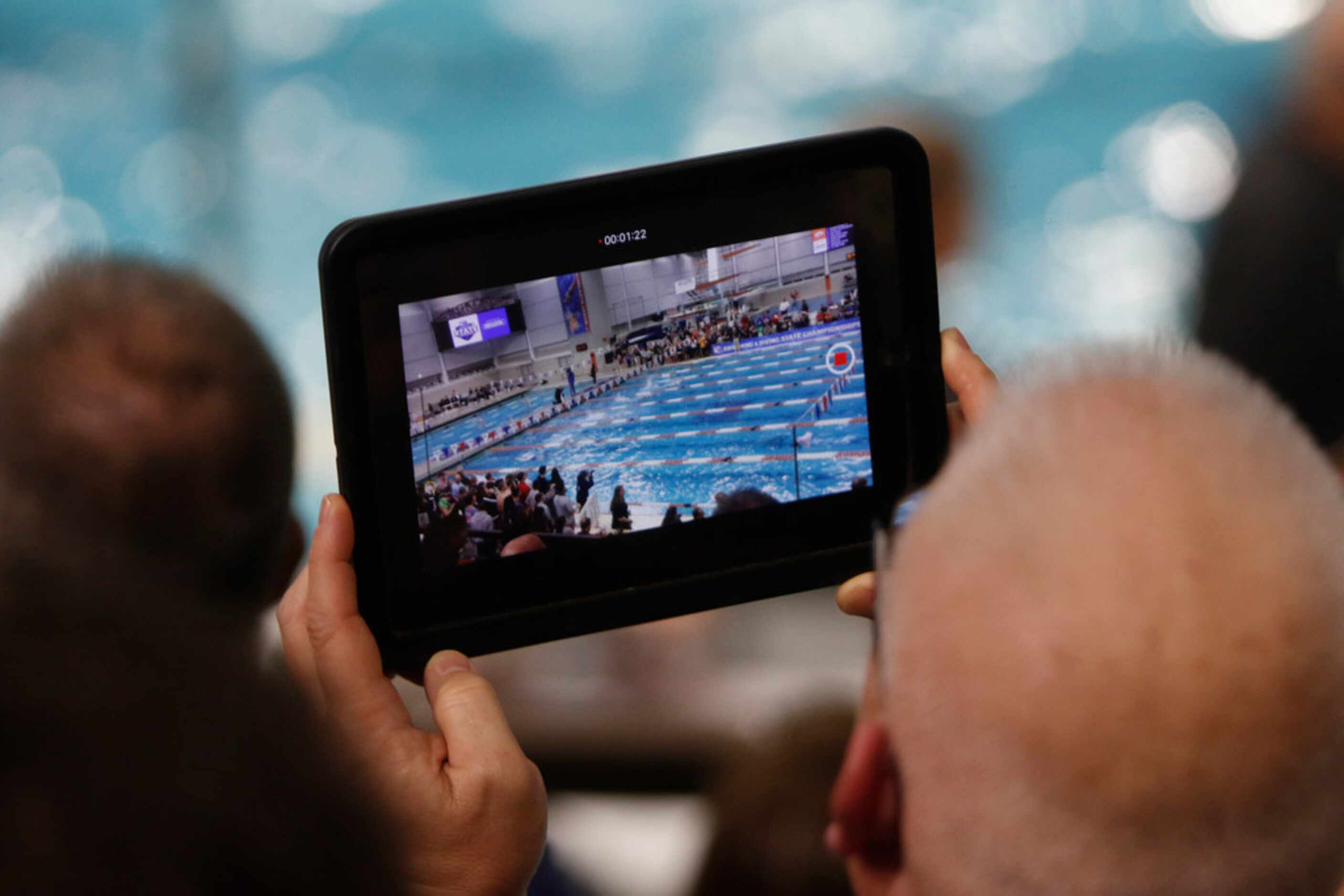 A swim fan records the action from his seat in the upper balcony. The UIL Class 6A state...