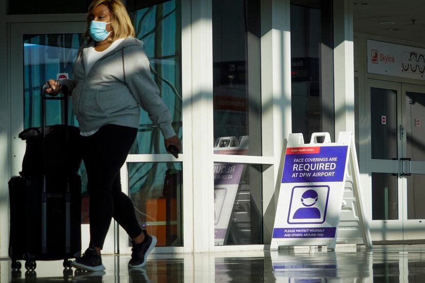Signs alert travelers to the continued federal mandate on the use of face masks due to the...