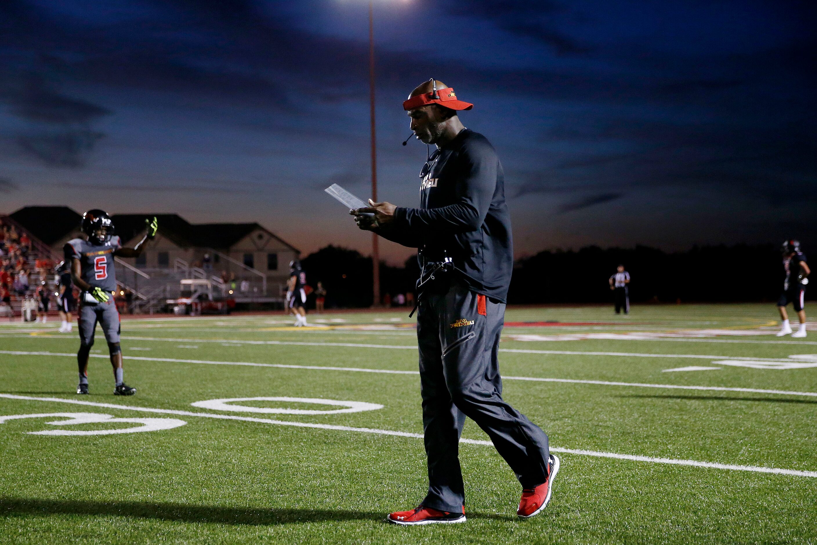 AAA Prime U coach Deion Sanders walks the sideline in the first half during a high school...