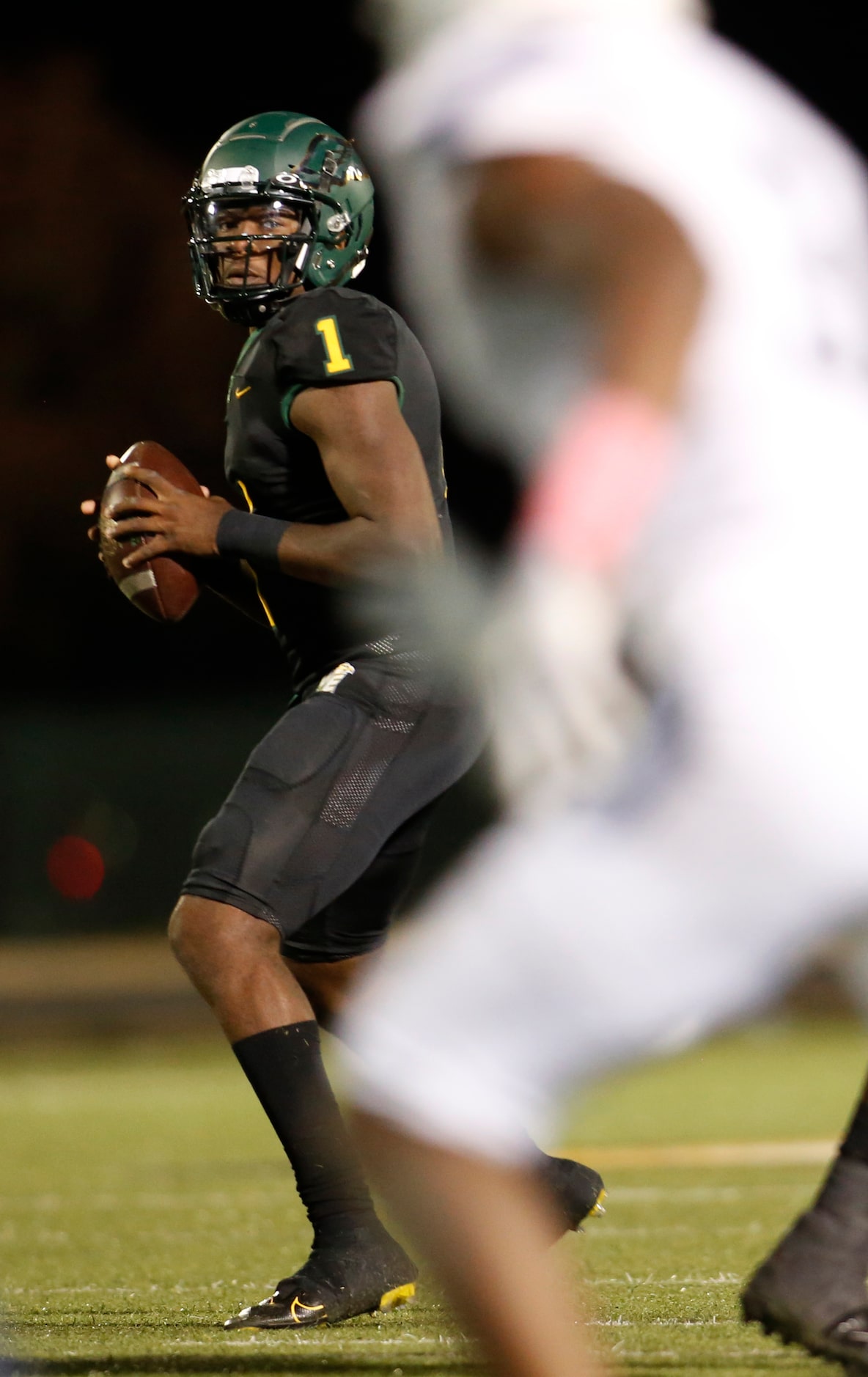 DeSoto quarterback Samari Collier (1) Looks for an open receiver during first quarter action...