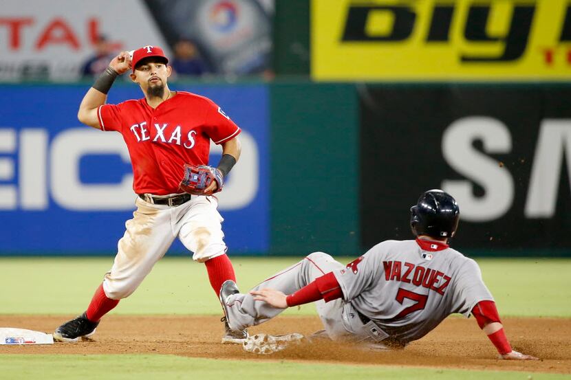 Texas Rangers second baseman Rougned Odor (left) completes a double play after forcing out...
