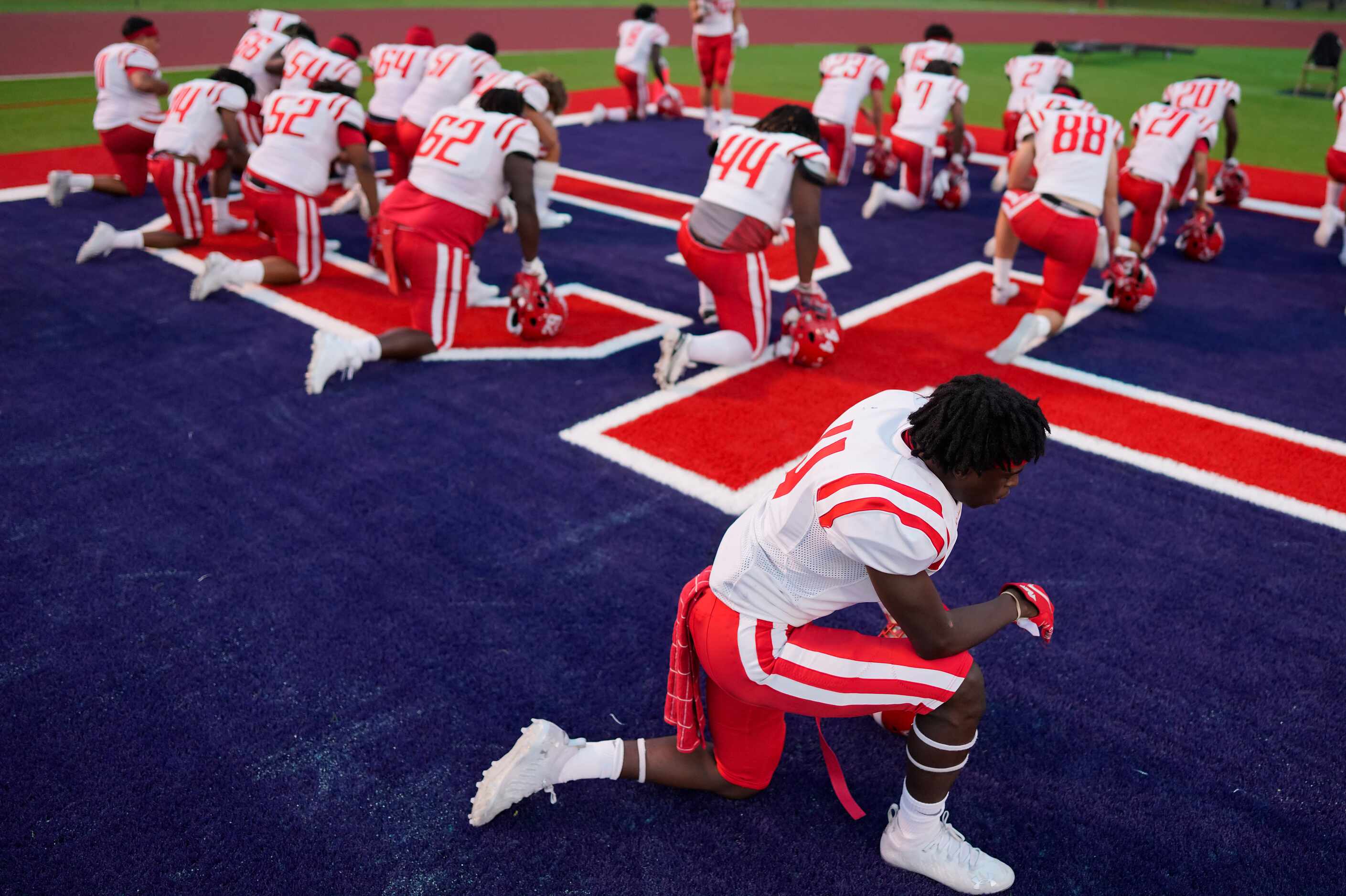 Terrell players kneel in prayer before facing Aubrey in a high school football game on...