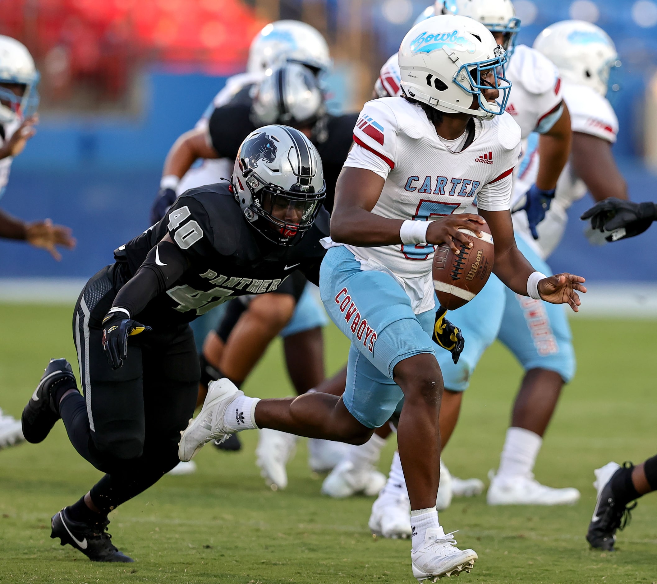 Dallas Carter quarterback Christopher Miller (5) scrambles to avoid the pressure from Frisco...