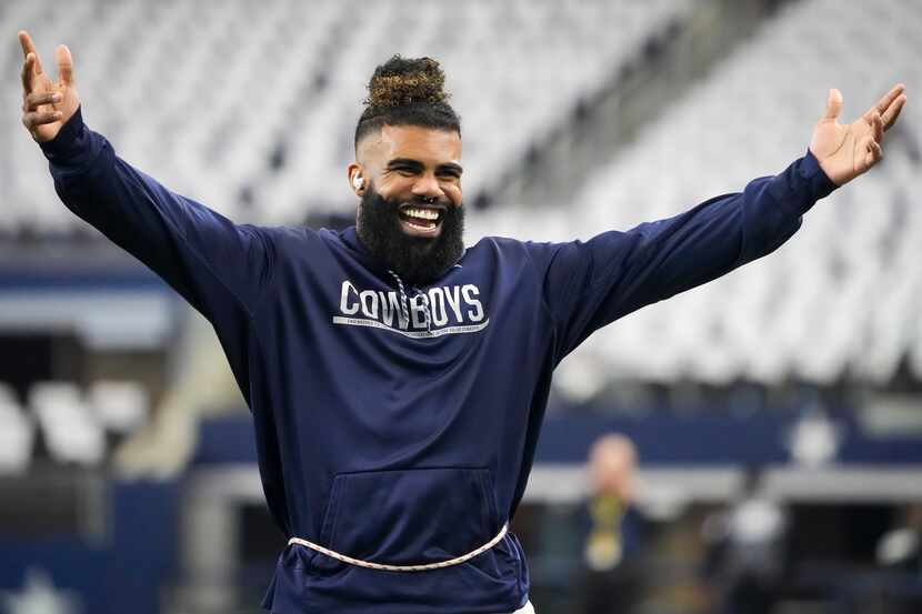 Dallas Cowboys running back Ezekiel Elliott motions to fans as the teams warm up before an...