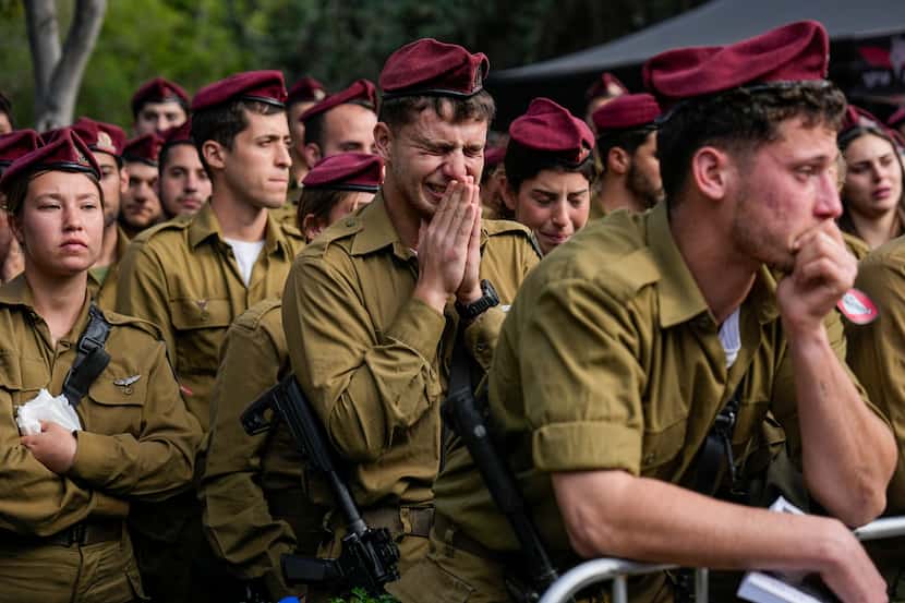 Israeli soldiers grieve during the funeral of Israeli Staff Sgt. David Sasson in Netanya,...