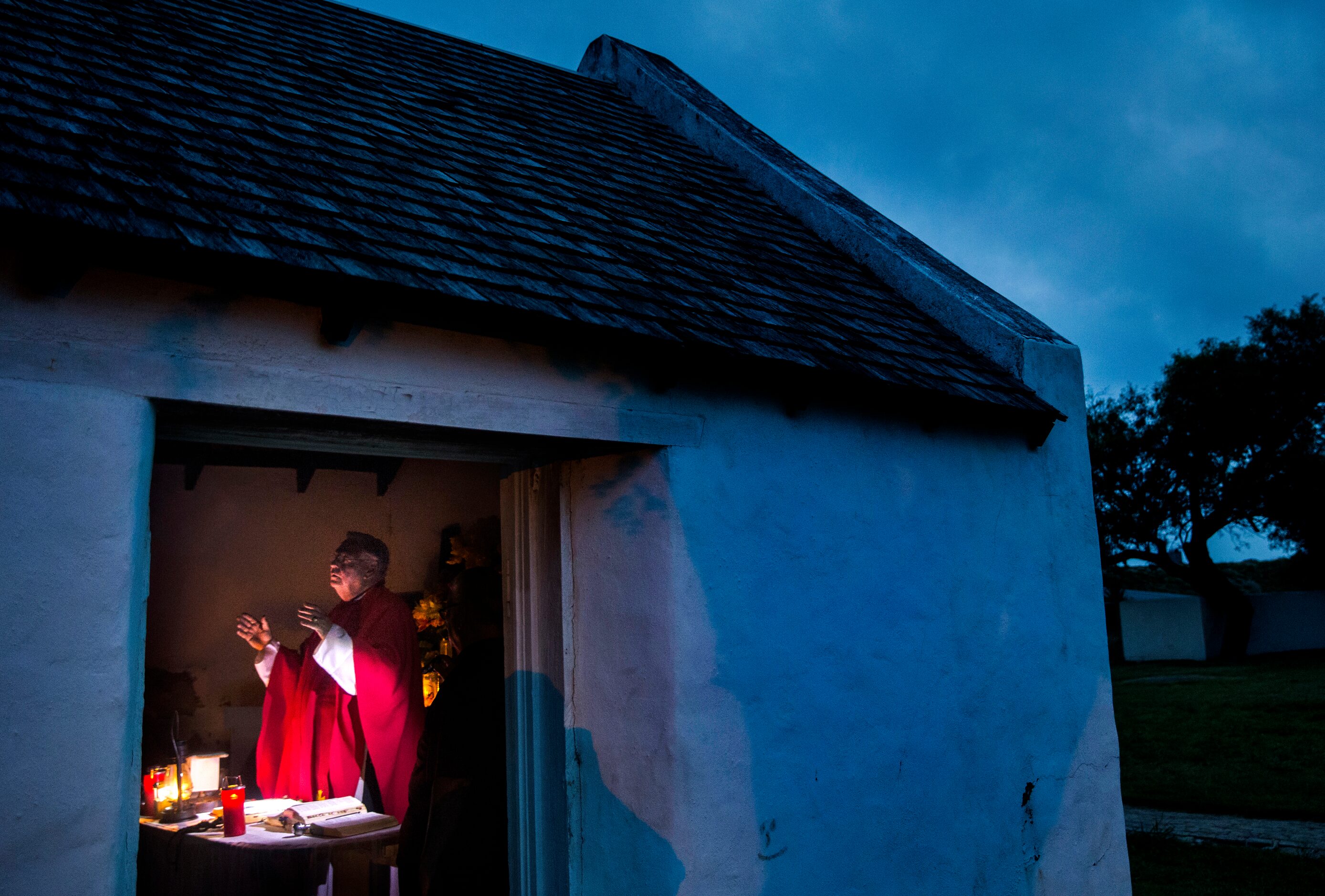 As the sun begins to rise, Father Roy Snipes opens a sunrise Mass at La Lomita chapel near...