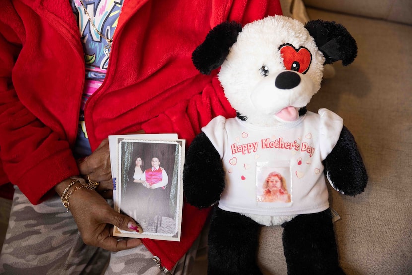 Isabel Murrugarra poses for a photo while holding photos of her with her son, Elian...