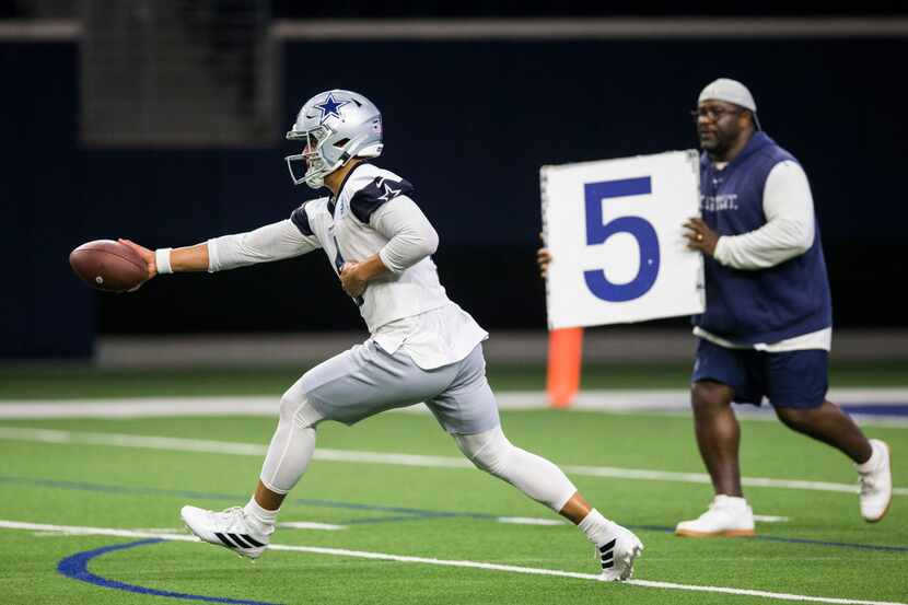 Dallas Cowboys quarterback Dak Prescott (4) hands off the ball during a Dallas Cowboys OTA...