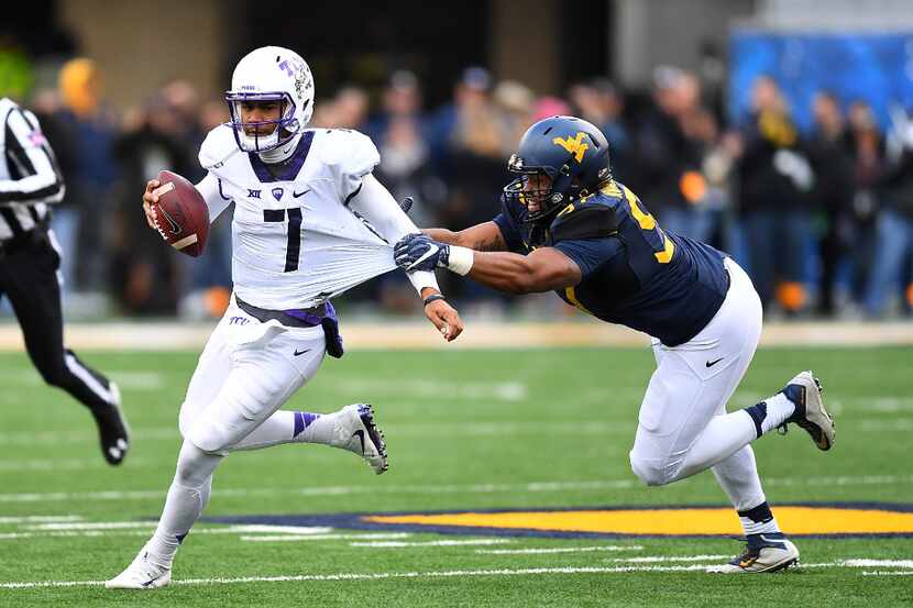 MORGANTOWN, WV - OCTOBER 22:  Kenny Hill #7 of the TCU Horned Frogs avoids a tackle by Noble...