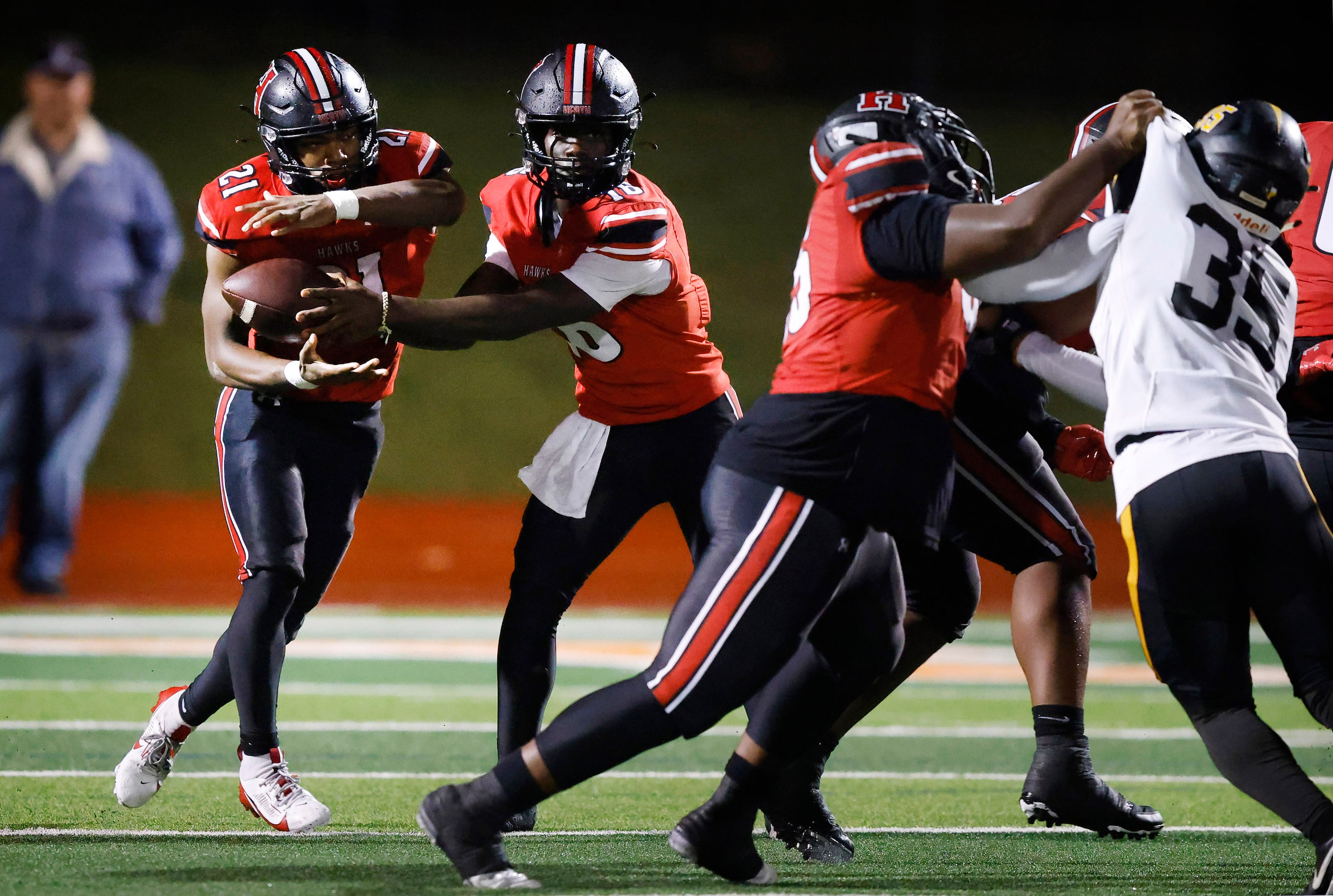 Rockwall-Heath quarterback Prosper Neal (16) hands the ball off to running back Ashton...