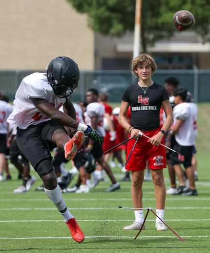 Lake Highlands High School kicker Shallum Peter (20) (left) practices kicking field goals...