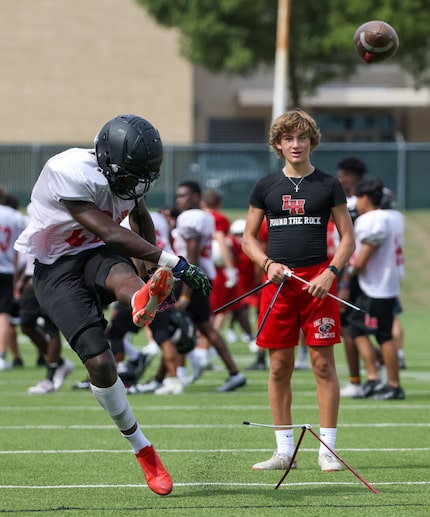 Lake Highlands High School kicker Shallum Peter (20) (left) practices kicking field goals...