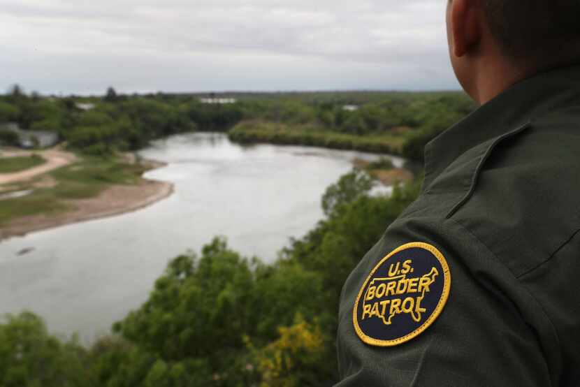 A U.S. Border Patrol agent scans the U.S.-Mexico border from a bluff overlooking the Rio...
