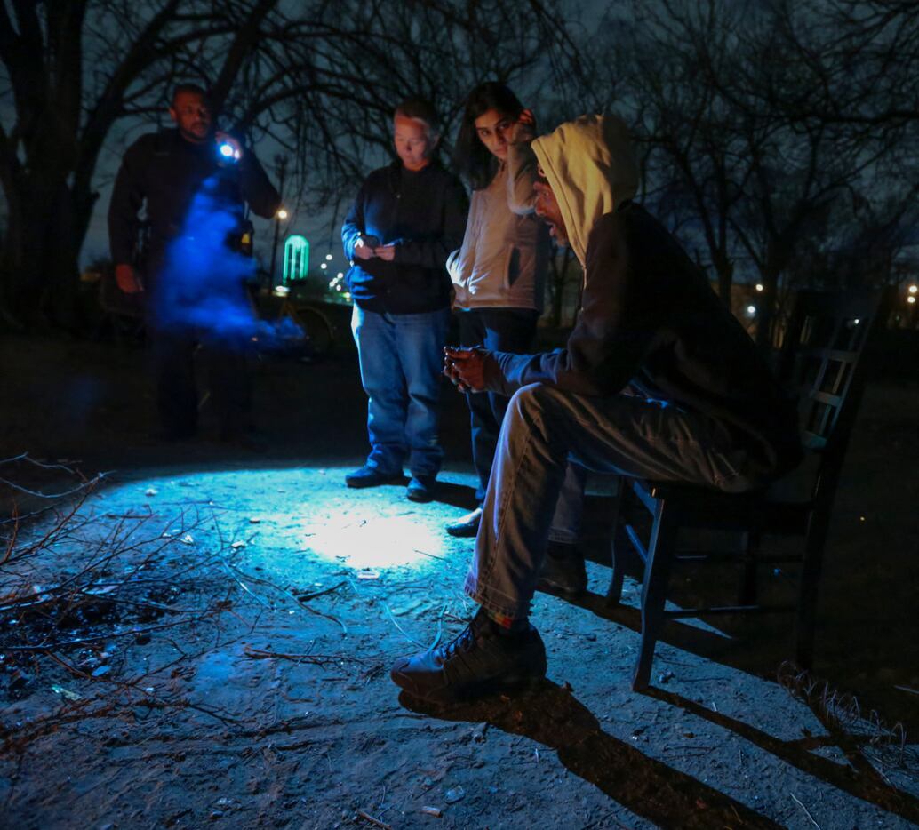 Dallas police Detective M. Stampley (left) used his flashlight to help Catherine Imes and...