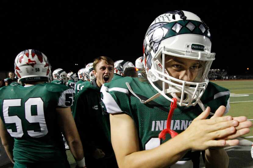 Waxahachie Indians sophomore quarterback Mason Brewer (16) rubs his hands together in...