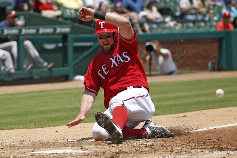 Texas Rangers catcher Bryan Holaday (8) scores in the third inning against Houston Astros...