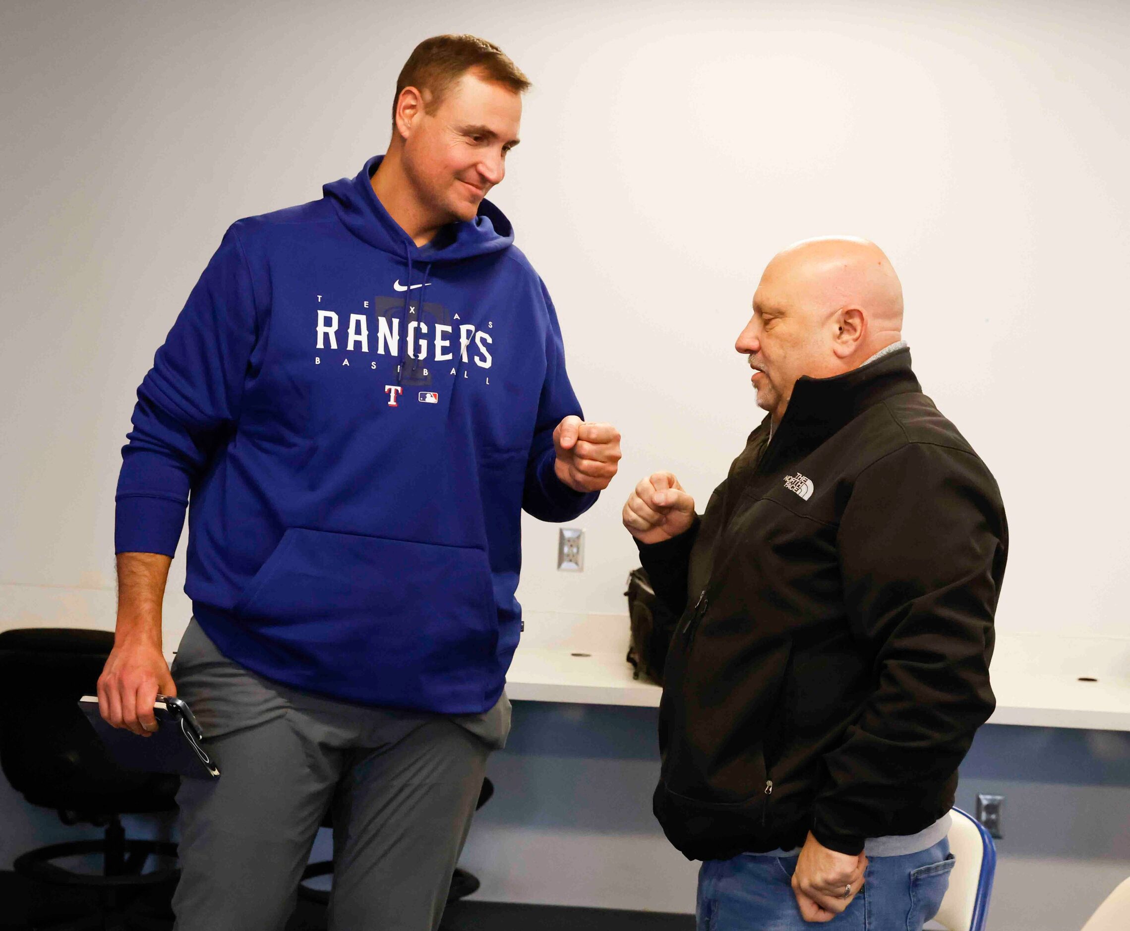 Texas Rangers executive vice president and general manager Chris Young, left, fist bumps...