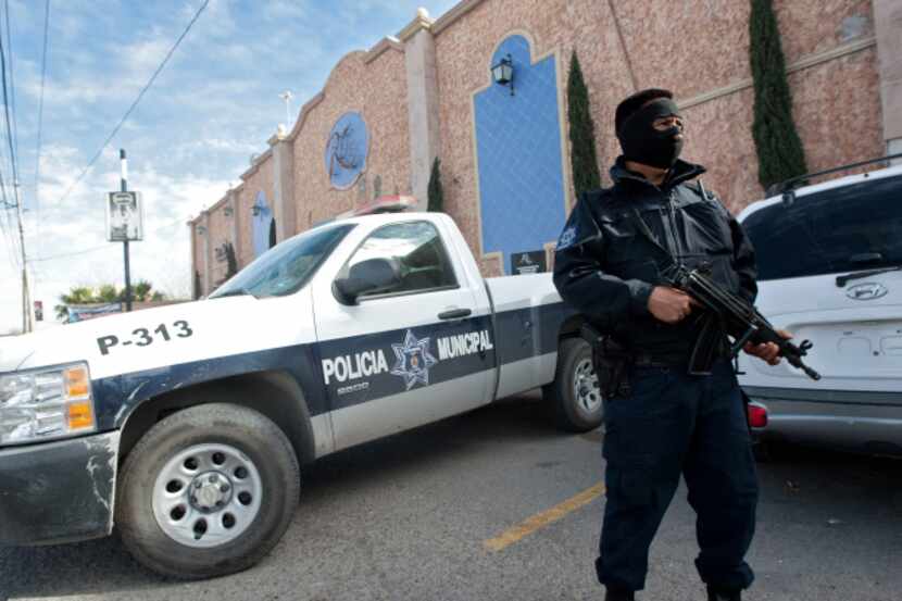 A police officer guarded a Juarez hotel where officers were staying in January to avoid...