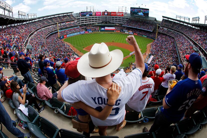 Texas Rangers and Michael Young fan Andrew Brown and his wife Andrea of Plano cheer during...