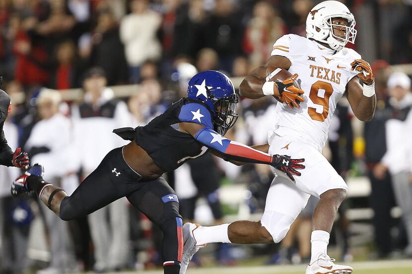 Texas' John Harris makes a catch ahead of Texas Tech's Nigel Bethel II during an NCAA...