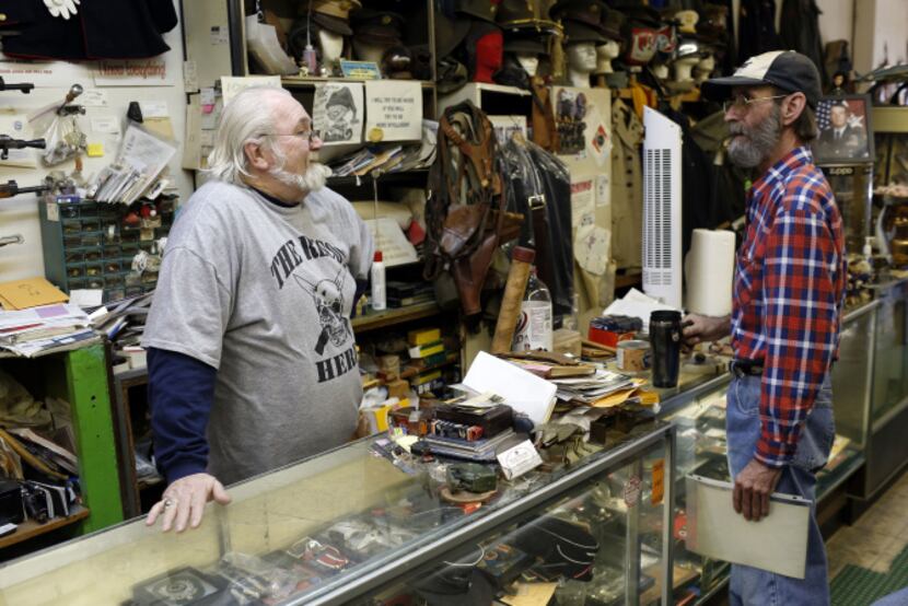 Recon Militaria owner D.J. Goodwin (left) trades stories with Clay Krakora, who picked up a...