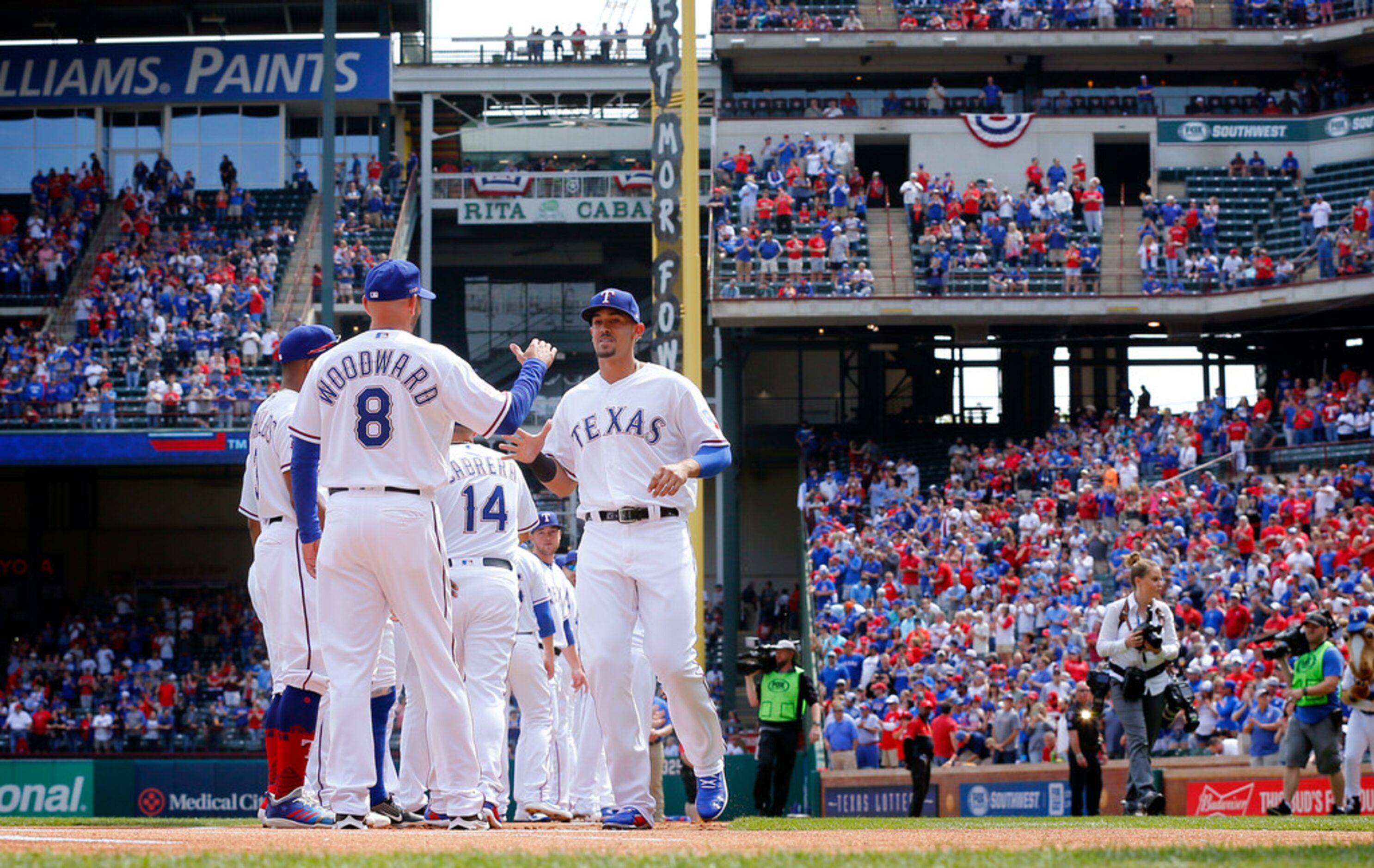 Texas Rangers manager Chris Woodward (8) greets outfielder Ronald Guzman during  Opening Day...