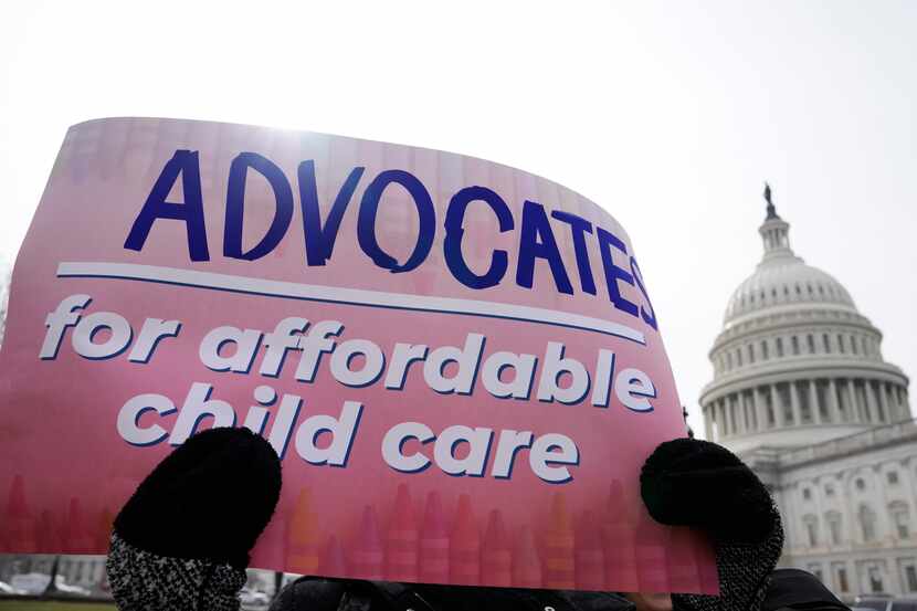 A person holds a sign during a news conference on child care relief on Capitol Hill in...