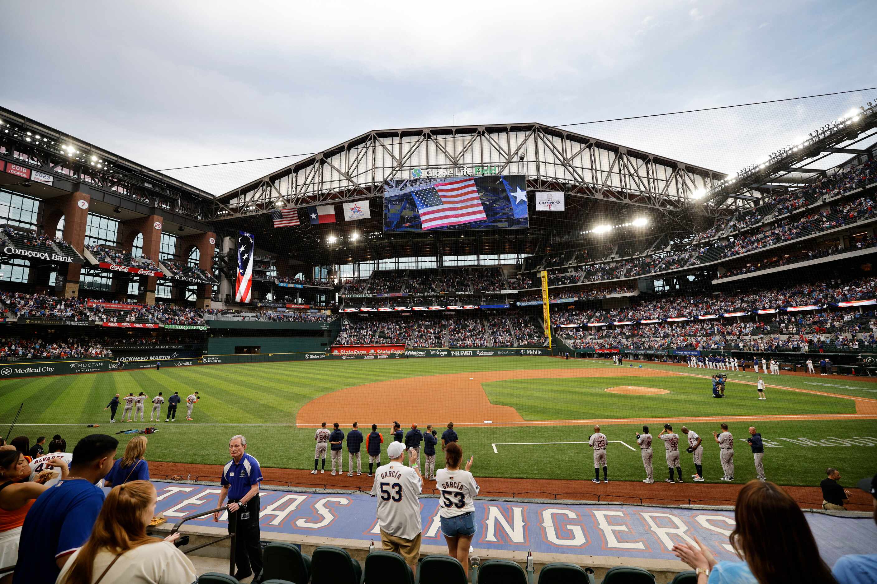 Players line up for the national anthem before a baseball game between Texas Rangers and...
