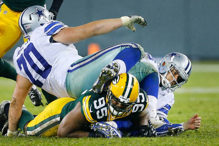 Dallas Cowboys guard Zack Martin (70) lands on top of his quarterback Matt Cassel (16) after...