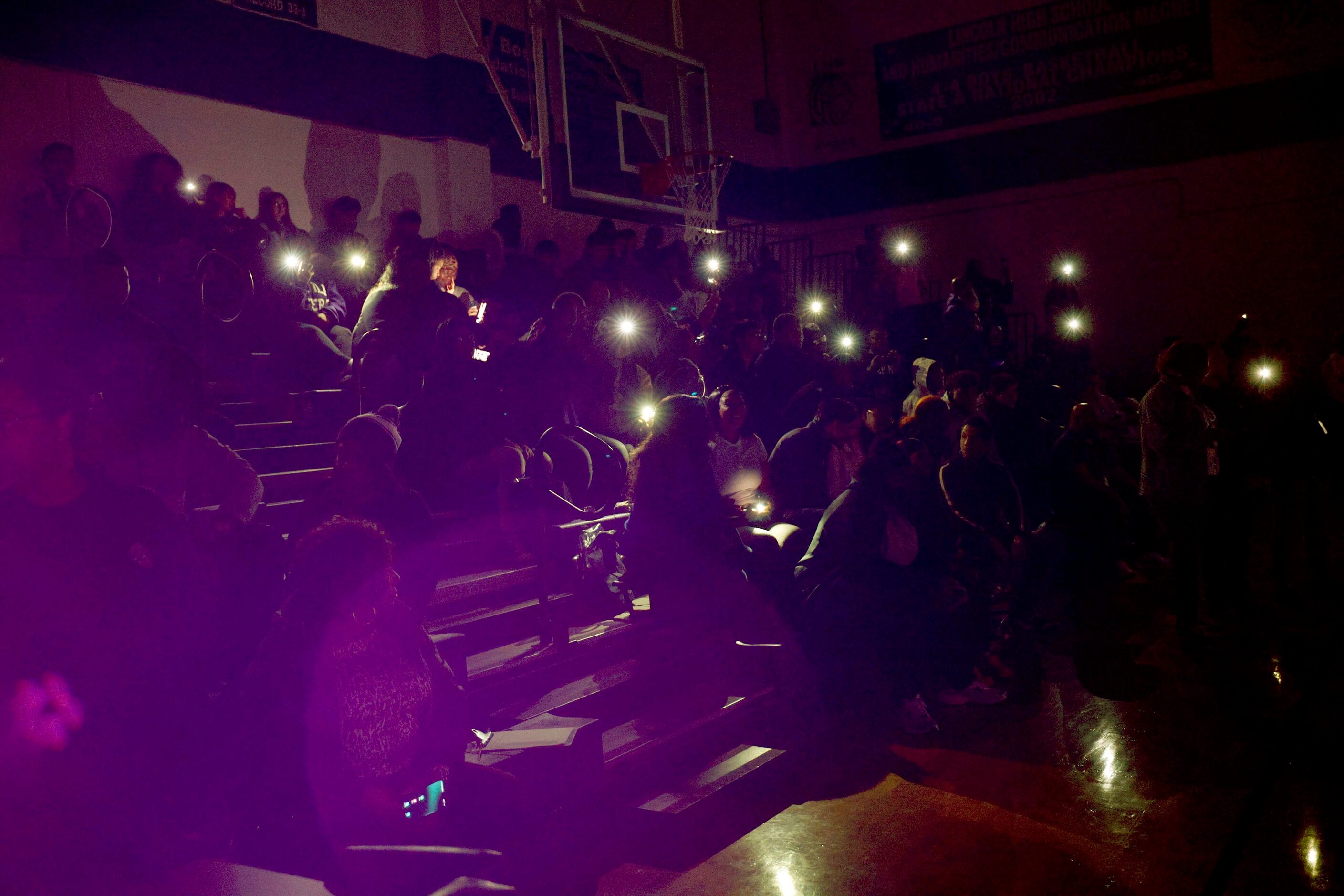 Lincoln High School students and staffers use cellphone lights before the introduction of...