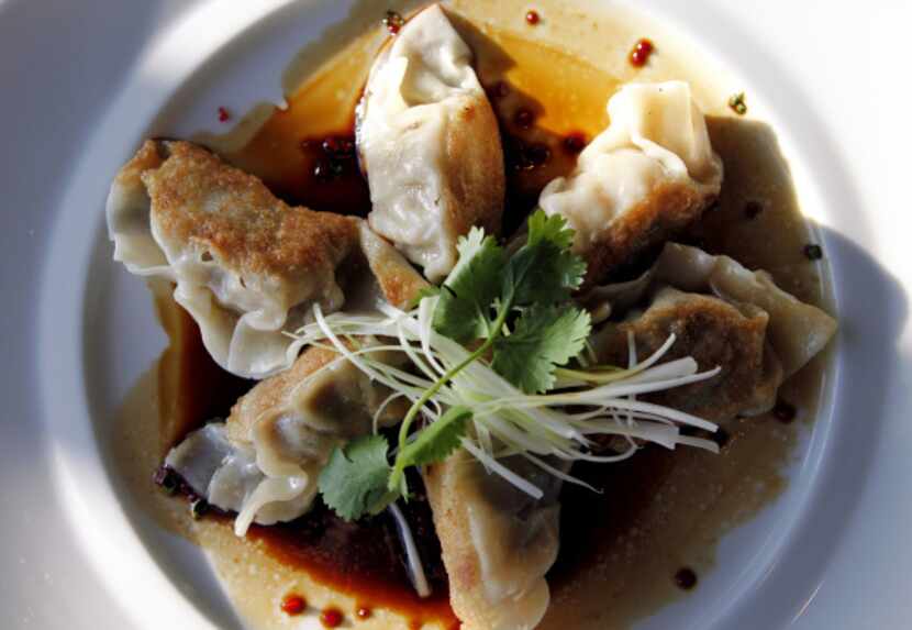 Pork belly pot stickers in a black vinegar sauce flecked with Fresno chiles.