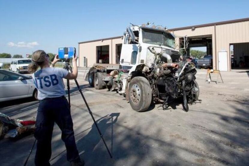 NTSB investigator Kristin Poland makes a laser scan of the truck that collided with a bus...
