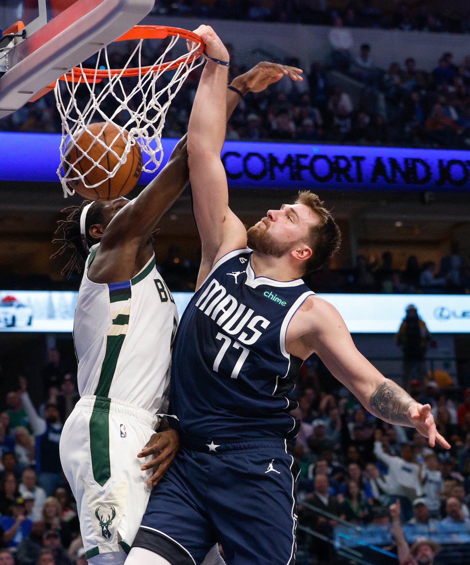 Dallas Mavericks guard Luka Doncic (77) dunks the ball over Milwaukee Bucks guard Jrue...