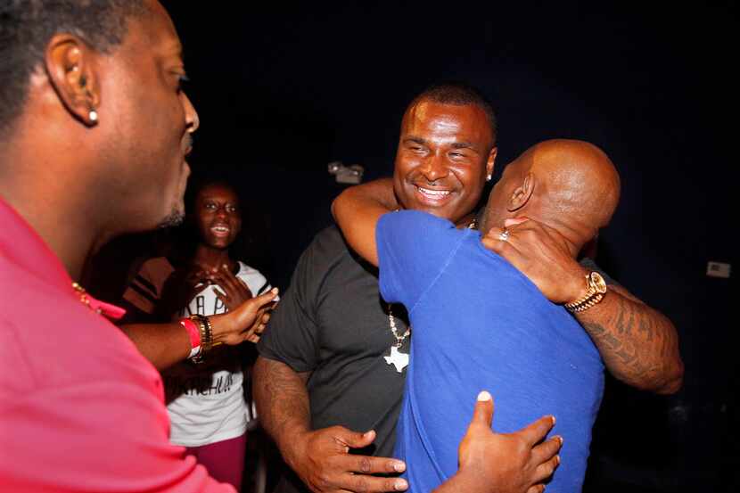 Former Carter and NFL football player Jessie Armstead (center) is greeted by old friends...