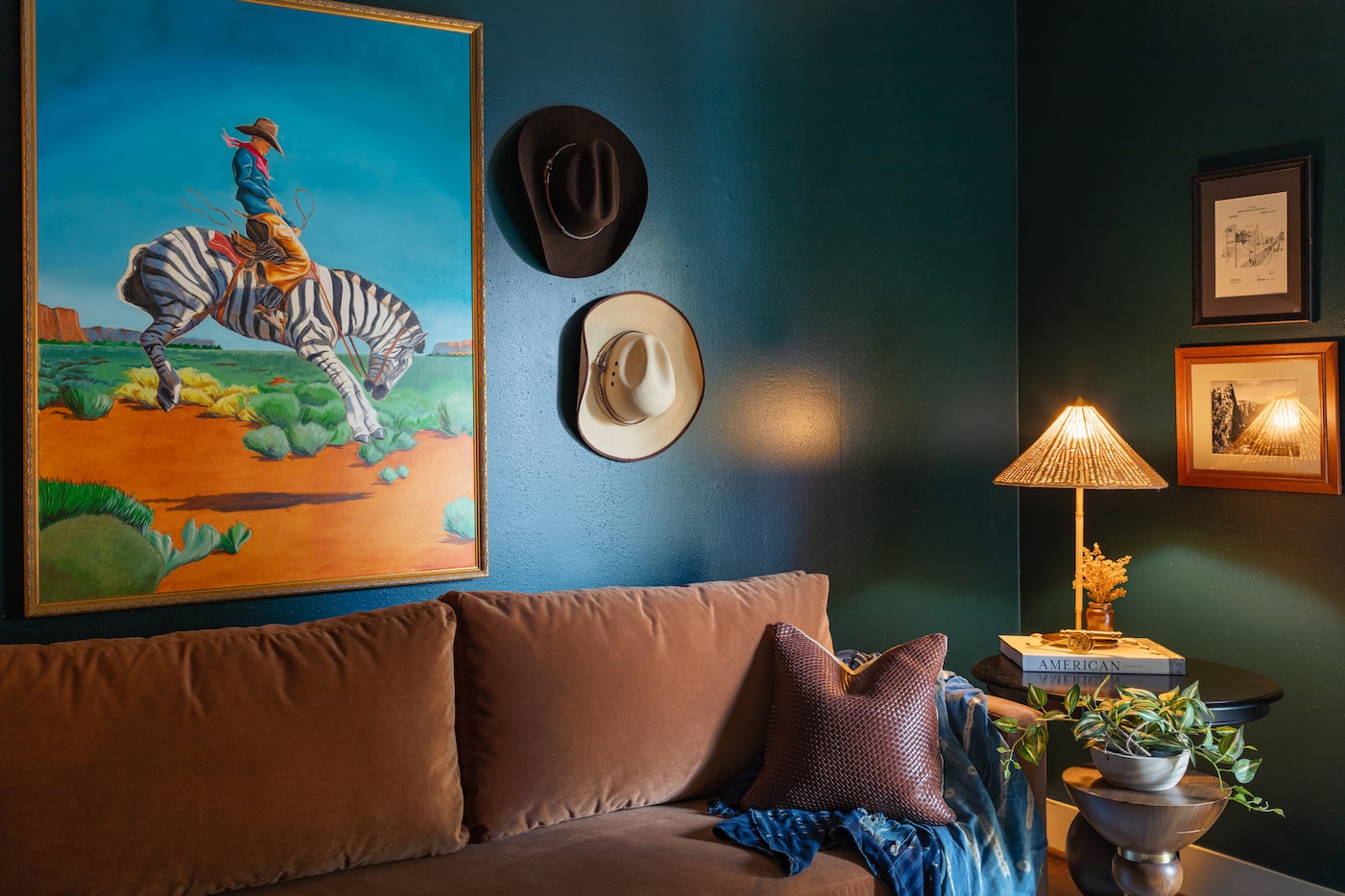 Living room with deep blue-green walls, brown sofa, Western theme