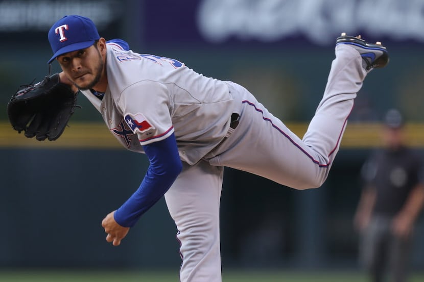 Texas Rangers starting pitcher Martin Perez works against the Colorado Rockies in the first...