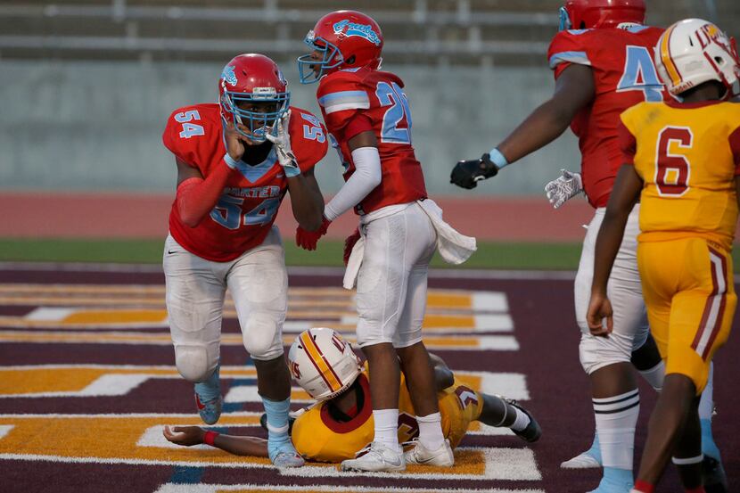 Dallas Carter players Randy Anthony (54) and Jv'Quavion Vinson (20) celebrate their safety...