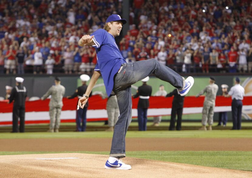 Dallas Mavericks' Dirk Nowitzki throws out the first pitch prior to the start of Game 3 of...