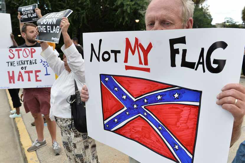 A man holds a sign up during a protest rally against the Confederate flag in Columbia, South...