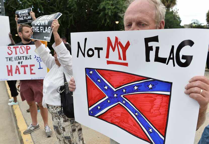 A man holds a sign up during a protest rally against the Confederate flag in Columbia, South...