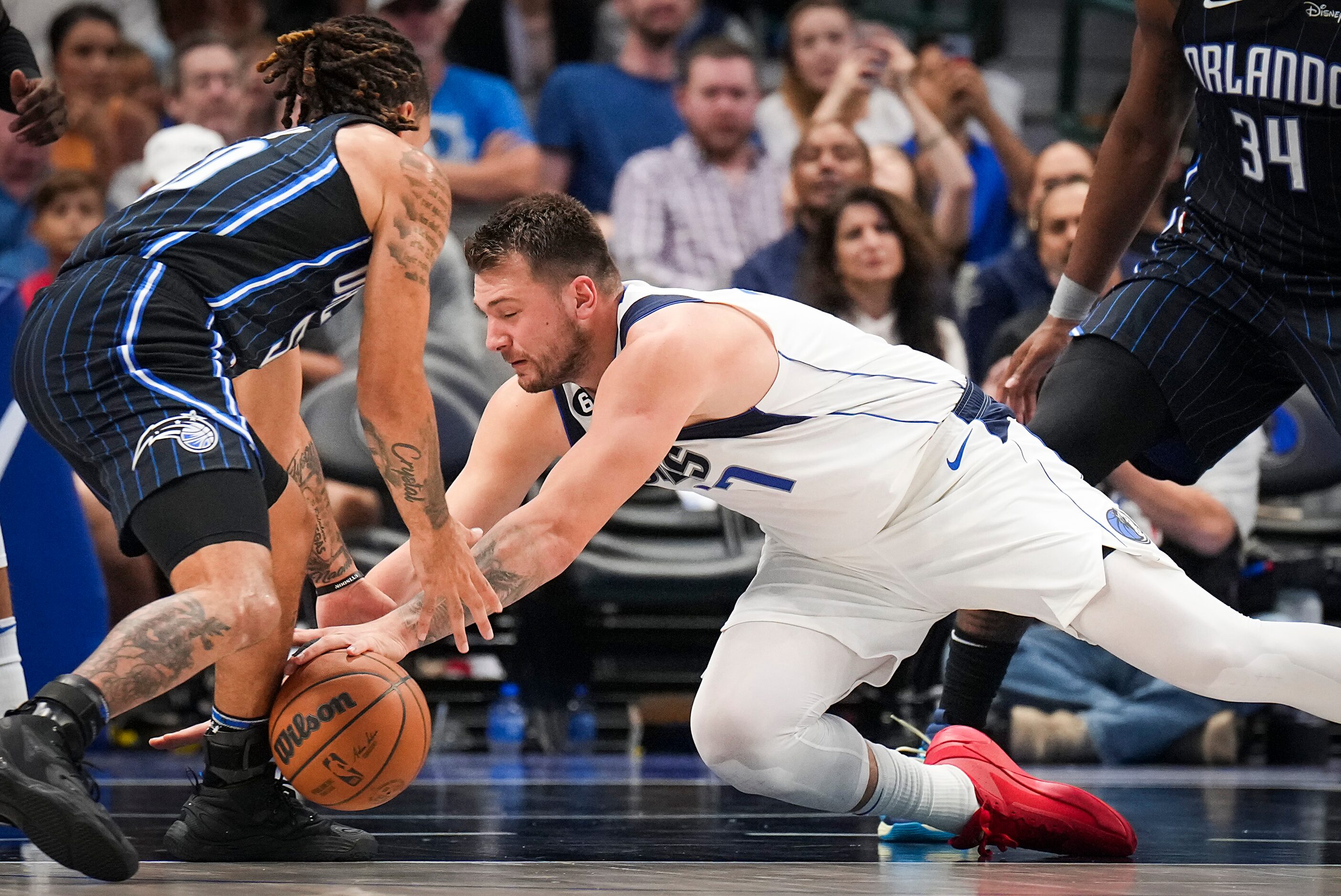 Dallas Mavericks guard Luka Doncic (77) reaches for a loose ball against Orlando Magic guard...