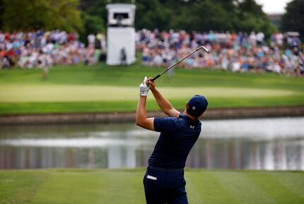 Professional golfer Jordan Spieth tees off across the water on the par-3, No. 13 during the...